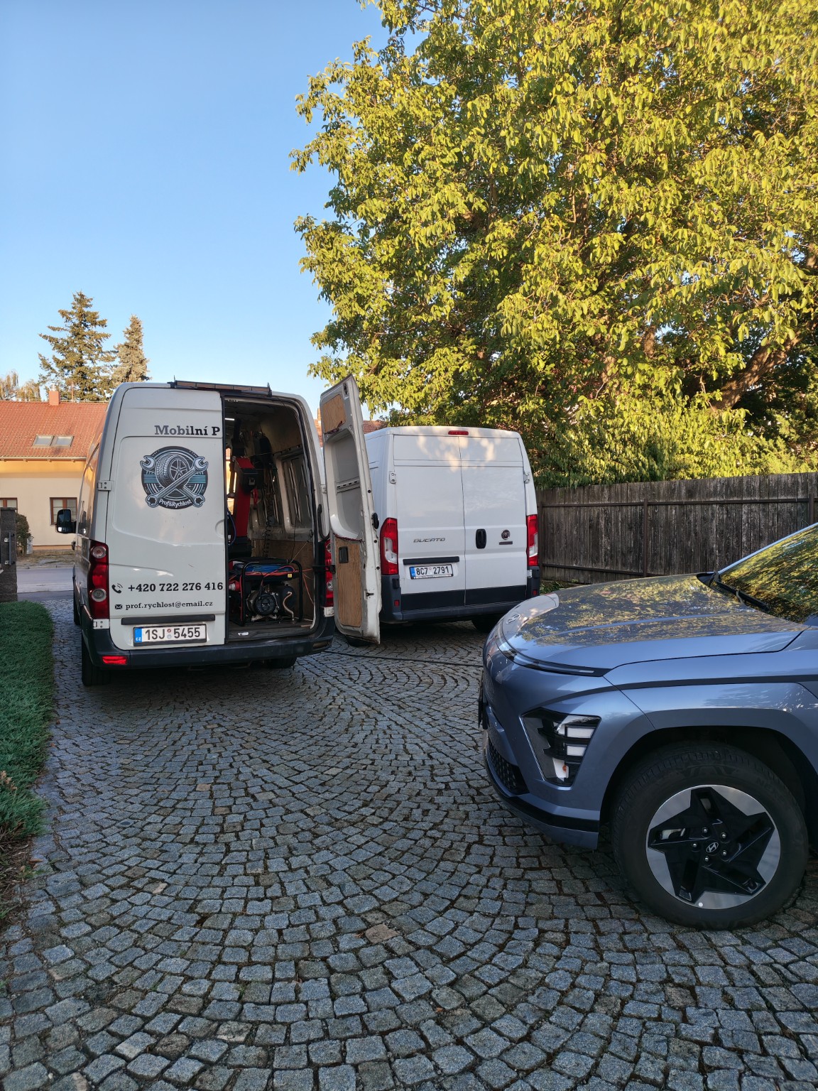 Servisní dodávka u zaparkovaného auta