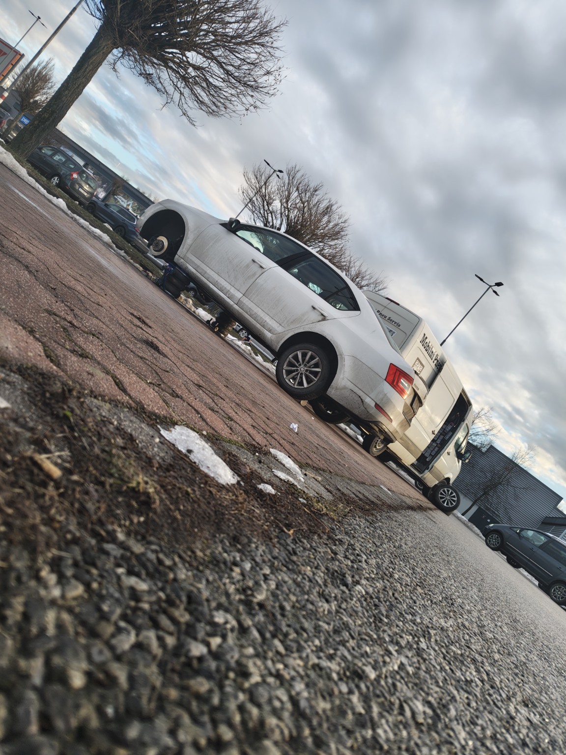 Bílé auto u servisní dodávky