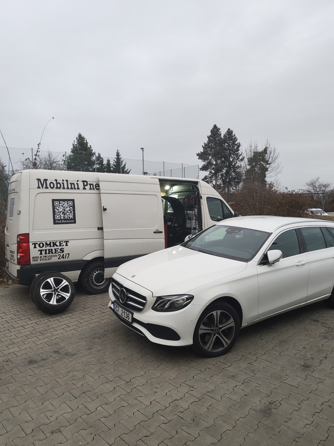 Servisní dodávka vedle bílého auta